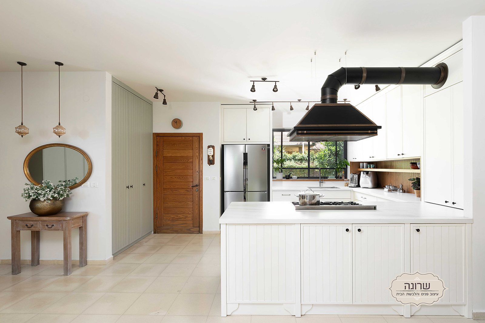 Bright white kitchen with a black hood in a Ramat HaKovesh house