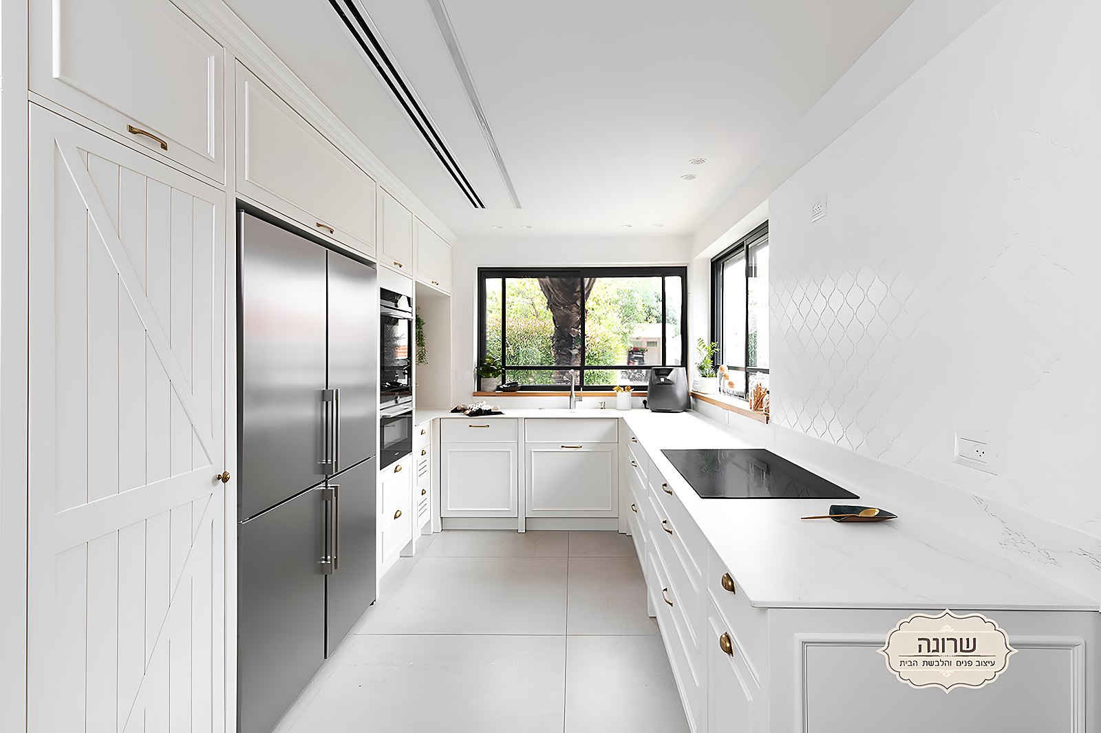 Modern white kitchen with a marble worktop and black-framed windows in a Pardesiya house